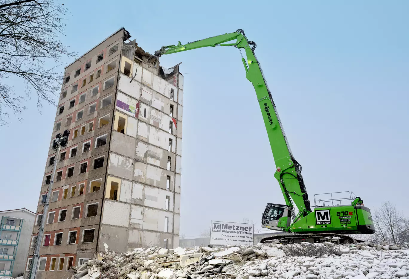 Der SENNEBOGEN 870 E Demolition Longfront Bagger gewährleistete den sicheren und präzisen Rückbau des innerstädtischen Plattenbaus.
