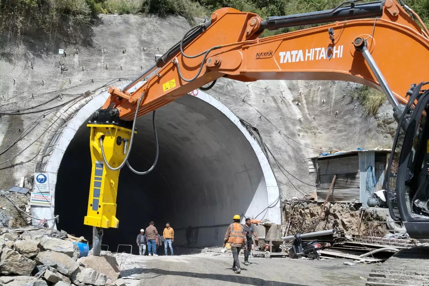 Beim Shimla Bypass Projekt in Indien kommt Epiroc Technik in geologisch anspruchsvollem Himalaya-Gelände zum Einsatz. Das rund 27,4 Kilometer lange Infrastrukturprojekt soll den Durchgangsverkehr aus Shimla herausführen, Staus reduzieren und die regionale Mobilität verbessern. In sensiblen Tunnelabschnitten stießen konventionelle Sprengverfahren an Grenzen, unter anderem wegen der Nähe zu bewohnten Bereichen sowie strenger Sicherheits- und Genehmigungsanforderungen. Epiroc empfahl nach einer technischen Analyse den Hydraulikhammer HB 3600 DP, um den Vortrieb auch bei eingeschränkten oder ausgesetzten Sprengarbeiten fortzuführen.
