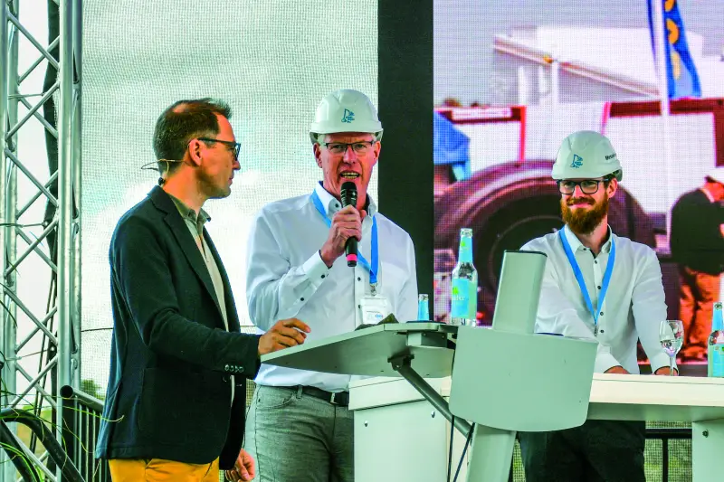 Generationswechsel an der steinexpo-Spitze. Dr. Friedhelm Rese (am Mikrofon), der die Demonstrationsmesse über Jahrzehnte geprägt und zu Europas bedeutendster Praxis-Messe im Steinbruch geformt hatte, übergab die operative Leitung an seinen Sohn Dominik Rese (r.), der für die steinexpo 2026 erstmals die alleinige Gesamtverantwortung als Messechef übernahm. Tobias Neumann (l.) führte durch die Pressekonferenz. Quelle: Treffpunkt.Bau