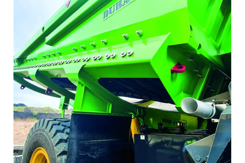 Gummi-Kippermulde von Komatsu. Die Alternative zur Stahlmulde hat zahlreiche Vorteile, darunter die massive Lärmreduzierung beim Beladen um bis zu 10 bis 15 dB(A). Zudem gibt Gummi unter den punktuellen Schlägen schwerer Felsbrocken nach und federt zurück, es treten keine Beulen oder strukturelle Risse durch Materialermüdung auf. Durch die Absorption der Stoßenergie wird obendrein das komplette Dumper-Fahrgestell geschont. Klebriges Abraummaterial oder feuchte Feinteile lösen sich beim Abkippen durch die Eigenbewegung des flexiblen Gummibodens wesentlich leichter als von glattem Stahl. Quelle: Treffpunkt.Bau