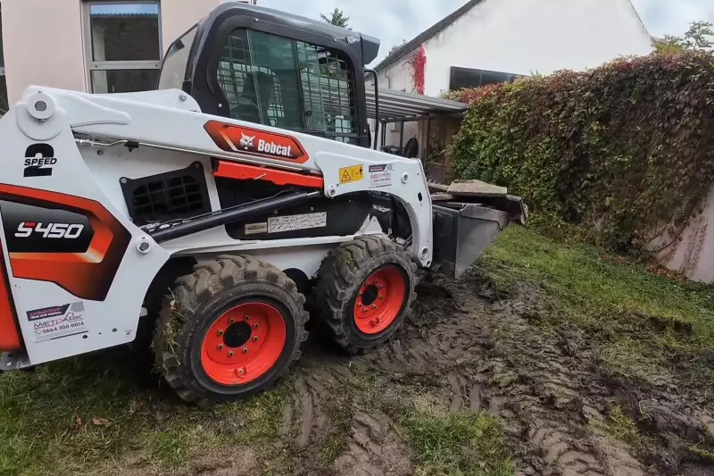 Die beengten Platzverhältnisse im Garten sind kein Problem für den wendigen Kompaktlader, der mühelos auf der Stelle manövriert.
