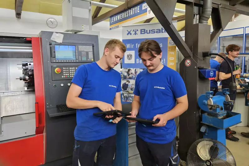 Zwei Busatis-Lehrlinge mit den neuen Arbeits-Tablets in der Lehrwerkstatt.