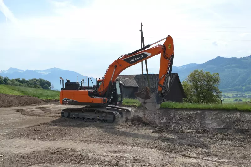 Prächtige Kulisse: Der autonom arbeitende DEVELON-Real-XKettenbagger DX225LC beim Praxiseinsatz im ehemaligen Steinbruch der KIBAG im schweizerischen Tuggen.
