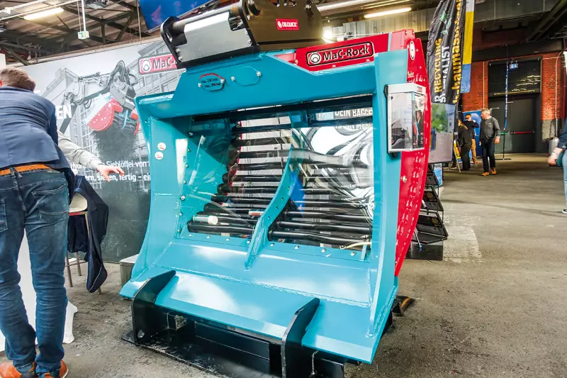 Effizienzsteigerung durch das Trennen von Materialien direkt vor Ort. Der Vortex von MaC-Rock ist ein Hochleistungs-Sieblöffel mit einer Tieflöffel-Geometrie. Der besondere „Vortex-Effekt“ entsteht durch die exzentrische Bewegung der Wellen, was ein Verkleben selbst bei feuchtem oder lehmigem Material verhindert. Quelle: Treffpunkt.Bau