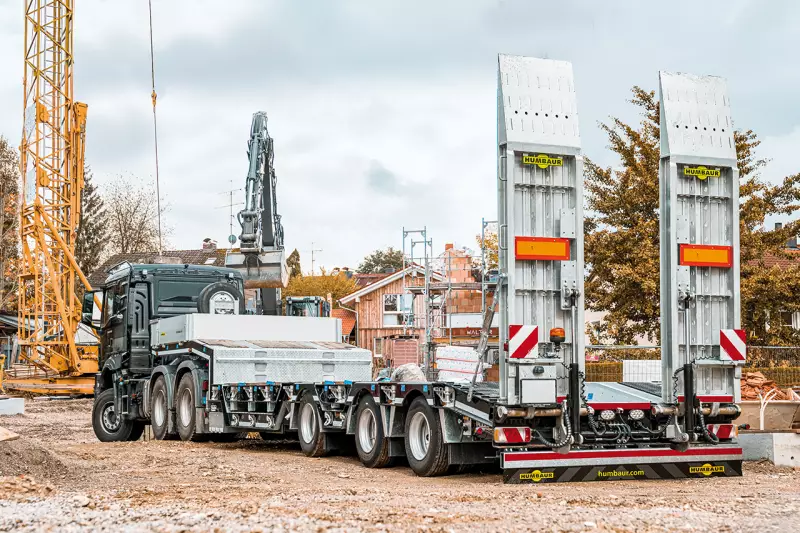 Der HTS 30 von Humbaur ist ein robuster Satteltieflader für hohe, bereifte Baumaschinen mit bis zu 48 t Gesamtgewicht und 35.200 kg Nutzlast. Hydraulische Rampen und ausziehbare Radmuldenabdeckungen mit Hartholzbelag erhöhen seine Praxistauglichkeit. Quelle: Humbaur
