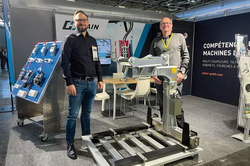 (V. l.)Christian Hain, Geschäftsführer Hain, und Klaus Sulzbacher, Vertriebsleiter, mit der Pister PowerFork PF2000. Die Palettengabel bietet eine Traglast von 2.000 kg und ist mit den gängigen Schnellwechseladaptern OQ40/SYMLOCK03/S-TYPE40 bis OQ45/SYMLOCK08/S-TYPE45 kompatibel. Quelle: Treffpunkt.Bau