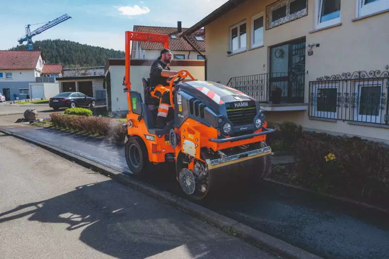Große Verdichtungskraft und hohe Präzision: Unmittelbar hinter dem Vögele Fertiger verdichtete die batterieelektrische Hamm Walze HD 12e VT den eingebauten Asphalt. 
