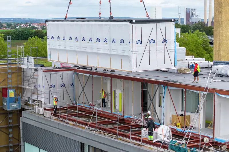Hochpräzise müssen Kran und Monteure die wuchtigen Module positionieren, damit am Ende das neue Stockwerk passgenau auf dem Klinikdach steht.