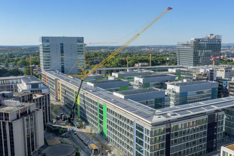 Millimeterarbeit in Luxemburg: Ein Liebherr-Mobilkran LTM 1650-8.1 tauscht Komponenten der Klimaanlage auf dem Dach des Europäischen Parlaments aus. Eine Hilfsspitze liefert die entscheidenden zusätzlichen 1,70 Meter Reichweite.