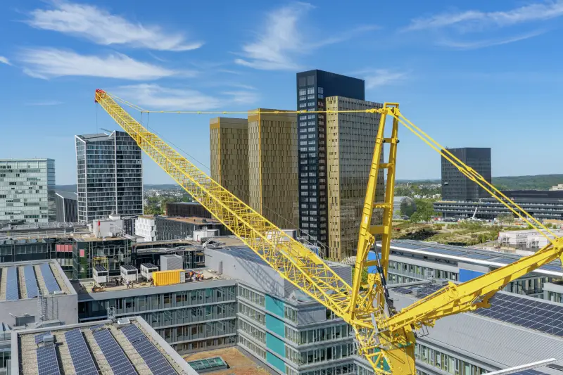 104 Meter Ausladung: Über die Dächer des Parlaments hinweg werden die bis zu fünf Tonnen schweren Anlagenkomponenten eingehoben. 