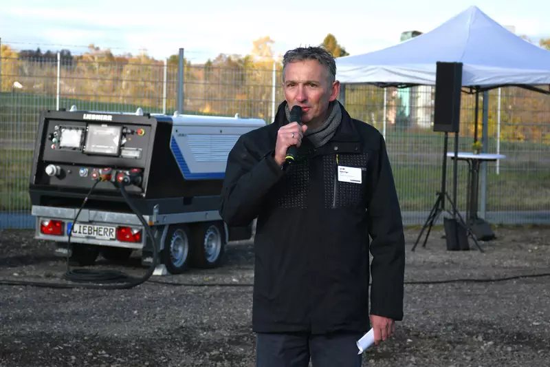 Mark Figel, Geschäftsführer Vertrieb bei Liebherr-Mischtechnik, begrüßte die Journalisten im Werk Bad Schussenried. Im Hintergrund der Liduro Power Port mit bis zu 160 kWh Speicherkapazität, der den LTC 1050-3.1 speiste. Quelle: Treffpunkt.Bau