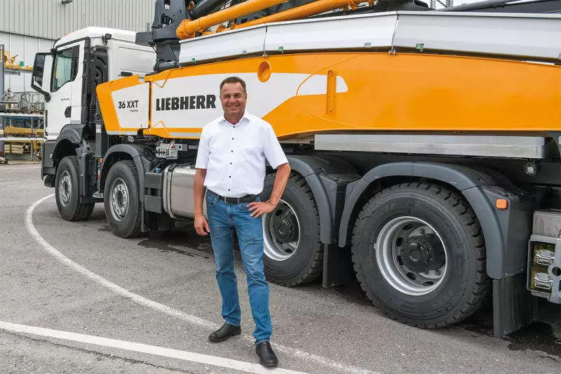 Klaus Eckert, Leiter Verkaufsförderung im Werk Bad Schussenried, mit der 36 XXT Autobetonpumpe. Das Volumenmodell von Liebherr mit einer vertikalen Reichweite von 35,8 m ist auch aufgebaut auf einem 3-Achs-Chassis erhältlich. Quelle: Treffpunkt.Bau
