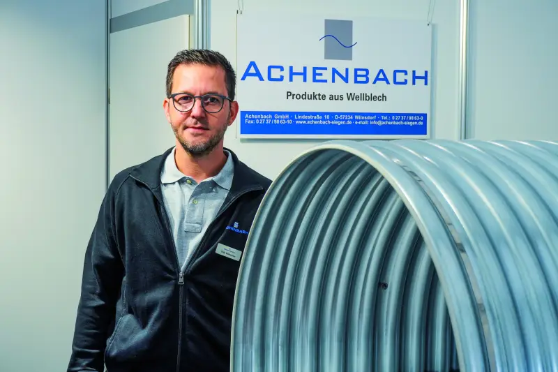 Achenbach Metalltechnik informierte über Förderbandabdeckungen für die Rohstoffindustrie. Im Fokus standen wetterfeste Hauben aus Stahl, Aluminium und Edelstahl, die Schüttgüter und Anlagentechnik schützen. Ergonomische Öffnungs- und Scharniersysteme ermöglichen einen schnellen, sicheren Zugang für Wartungsarbeiten. Neben standardisierten Ausführungen zeigte Achenbach maßgeschneiderte Sonderlösungen für komplexe Bandgeometrien sowie Systeme zur Lärm- und Staubreduzierung im Steinbruchbetrieb. Quelle: Treffpunkt.Bau