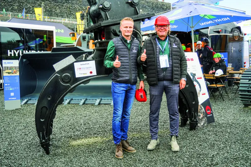 Mörtlbauer Baumaschinen präsentierte als Partner am Hyundai-Messestand sein SkanCraft-Portfolio für den extremen Einsatz im Erdbau, Steinbruch und Abbruch. Ein Fokus lag auf dem Steingreifer, der mit bis zu 2.500 mm Öffnungsweite auch unförmige Felsen, wuchtige Steine oder Rundhölzer greift, sicher festhält und exakt an den gewünschten Ort platziert. Dank ineinandergreifender Arme und gewellter, verstärkter Seitenschalen lassen sich neben riesigen Felsen auch kleinere Steine oder Holzstücke leicht greifen, wie uns Walter Hannes Mörtlbauer (l.) und Walter Rainer Mörtlbauer sagten. Quelle: Treffpunkt.Bau