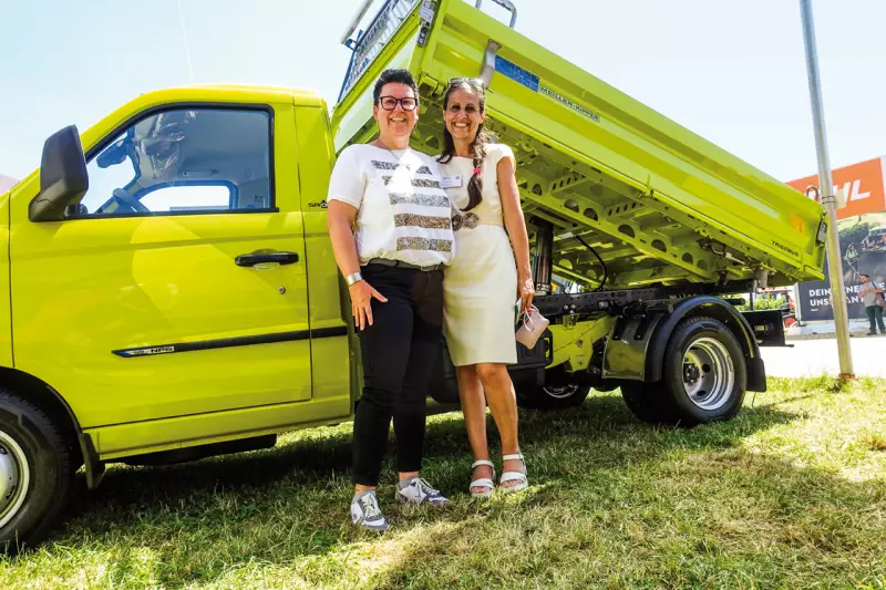 Sie strahlten mit der Sonne um die Wette: (v.l.) Elisabeth Egger, Meiller, und Francesca Mazzaccheri, Piaggio, vor dem Trigenius D202 auf dem Piaggio Porter NP6. Die robuste Stahlpritsche vereint geringes Eigengewicht mit cleveren Stauraumlösungen. Quelle: Treffpunkt.Bau