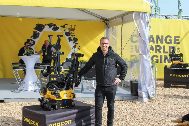 Michael Gerstbrein, Country Manager Engcon, neben dem EC-Oil. Mit dieser vollautomatischen Hydraulikkupplung können Anwender hydraulische Anbaugeräte in Sekundenschnelle wechseln oder den Tiltrotator abkoppeln, wenn sie mehr Brechkraft benötigen. Quelle: Treffpunkt.Bau
