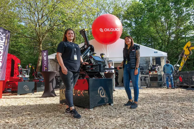 Mit Tiltrotatoren, Schnellwechselsystemen und Hydraulik-Magneten von Oilquick geht die Arbeit schneller und besser. Welche Anbaugeräte sich für welchen Einsatz eignen, erfuhren Messebesucherinnen und -besucher bei (v. l.) Medina Becirovic, Marketingmanagerin, und Anne Betz, Vertriebsinnendienst. Quelle: Treffpunkt.Bau

