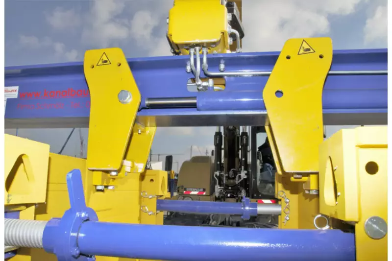 Keine Ketten mehr. Der SchachtFix-Verbaugreifer nimmt hydraulisch gesteuert die modifizierten SBH Verbauplatten auf. Das System Schmölz spart den bislang nötigen Helfer und reduziert die Einbauzeit um bis zu 20 %.