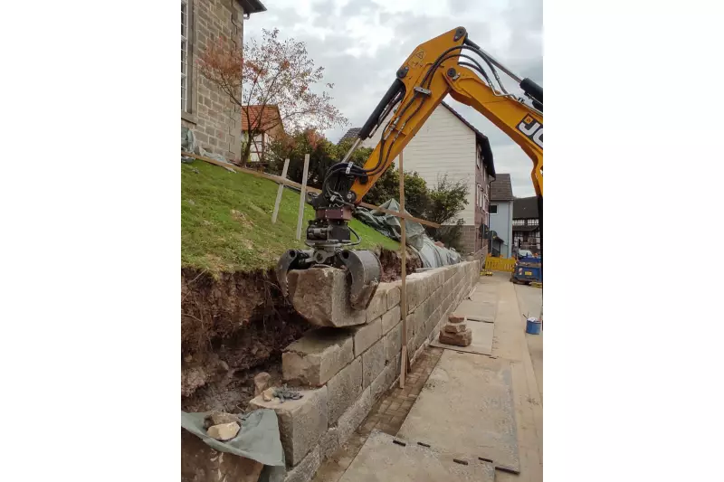 Präzision und zügiges Arbeiten beim Bau von Natursteinmauern: Hier sind RotoTop und der MultiGrip von Holp im Einsatz.