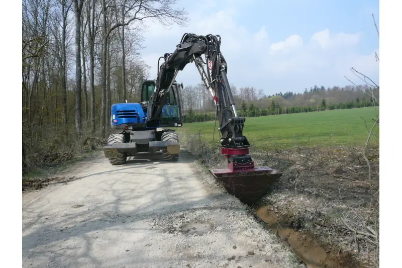 Die Kombination von RotoTop und VarioLöffel sorgt für den effizienten Bau von Gräben neben Straßen und Wegen – als wichtige Hochwasserschutzmaßnahme.
