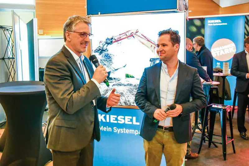 Kiesel, Schwerpunktpartner des diesjährigen VDBUM-Großseminars, präsentierte sich als ganzheitlicher Systemanbieter mit Premium-Maschinen, innovativer Schnellwechsler-Technik und einer starken Service-Infrastruktur, die den Kunden hilft, die Maschinen maximal auszulasten. Im Rahmen des Presserundgangs interviewte VDBUM-Geschäftsführer und -Vorstandsmitglied Dieter Schnittjer (l.) Maximilian Schmidt, Geschäftsführer der Kiesel GmbH. Quelle: Treffpunkt.Bau
