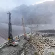 Auf der alpinen Baustelle arbeiten das Bohrgerät LB 45 und der Seilbagger HS 8070 HD von Liebherr im Teamwork.