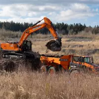 Eingespieltes Doppel: Der DX400HD aus der neuen 9er-Serie beim Beladen des knickgelenkten Dumpers DA30. Beide Maschinen beweisen sich auf dem Demo-Gelände der steinexpo.

