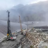 Auf der alpinen Baustelle arbeiten das Bohrgerät LB 45 und der Seilbagger HS 8070 HD von Liebherr im Teamwork.