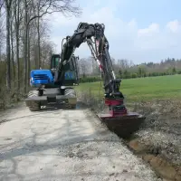 Die Kombination von RotoTop und VarioLöffel sorgt für den effizienten Bau von Gräben neben Straßen und Wegen – als wichtige Hochwasserschutzmaßnahme.
